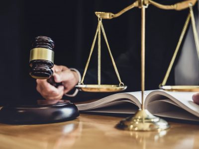 Male lawyer or judge working with contract papers, Law books and wooden gavel on table in courtroom, Justice lawyers at law firm, Law and Legal services concept.